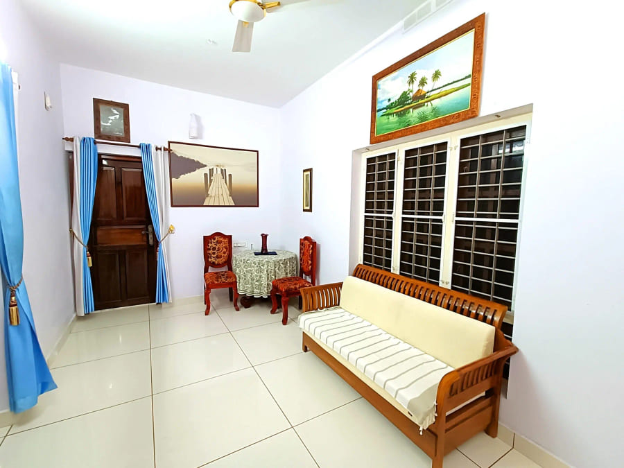 Sitting room of a guest room with a traditional wooden settee