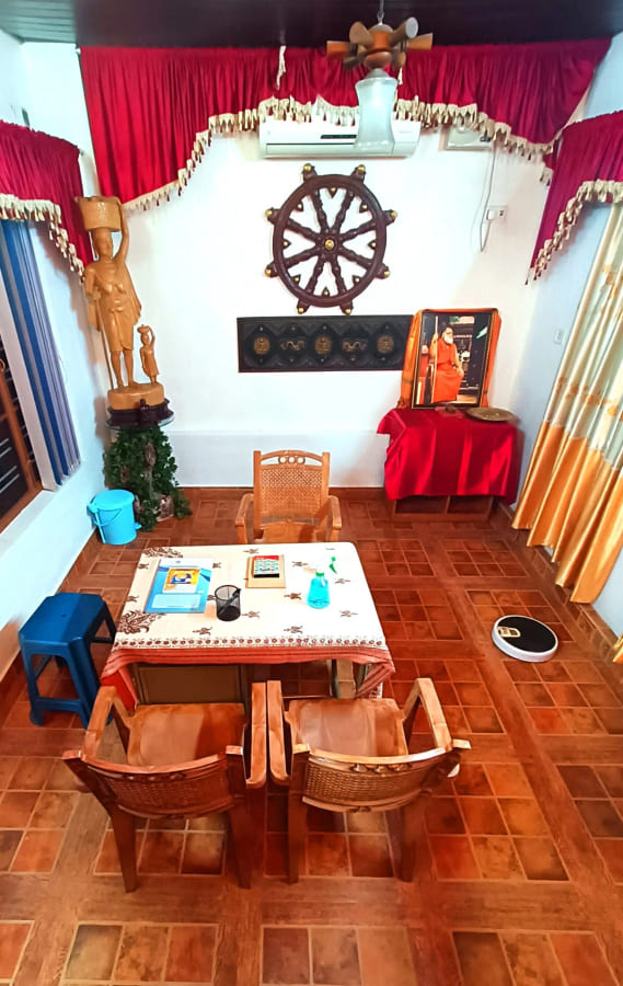 Ashram office with a small shrine, a dharma wheel and a worktable