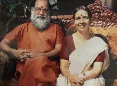 Guru Balachandran Nair seated beside Amma at the ashram