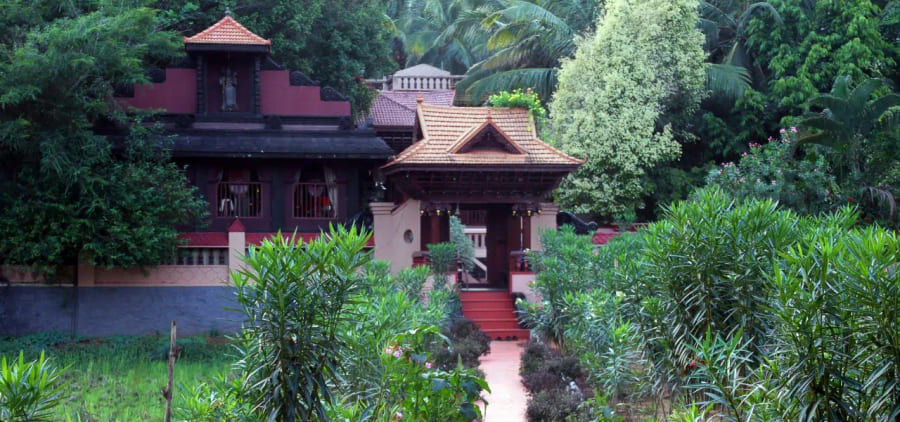 Tiled roof and entrance steps of a traditional building among the greenery