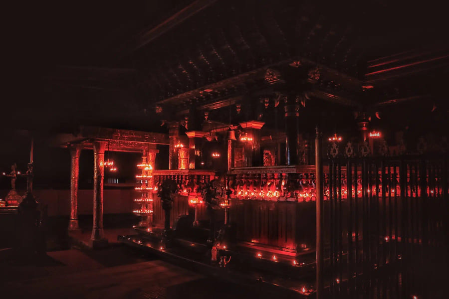 The carved timber temple lit for an evening ceremony