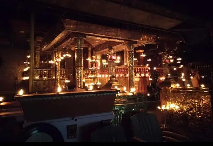 Carved wooden eaves and hanging lamps above the shrine