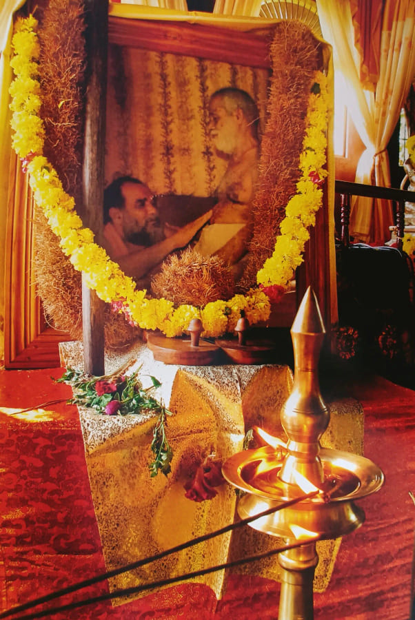 A priest at the garlanded shrine during a pooja