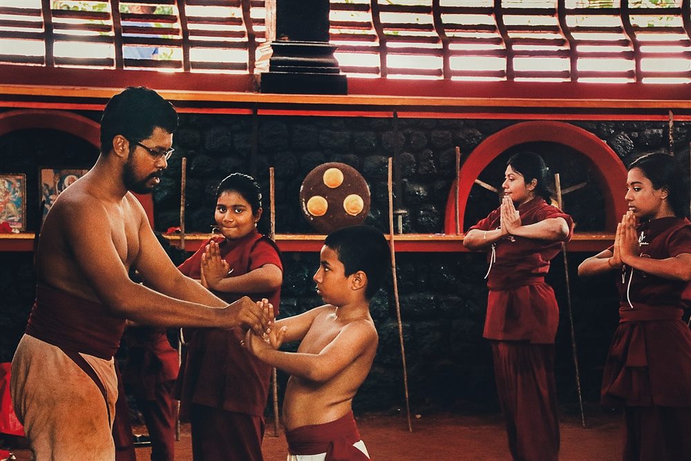A master guiding young students through a locking technique