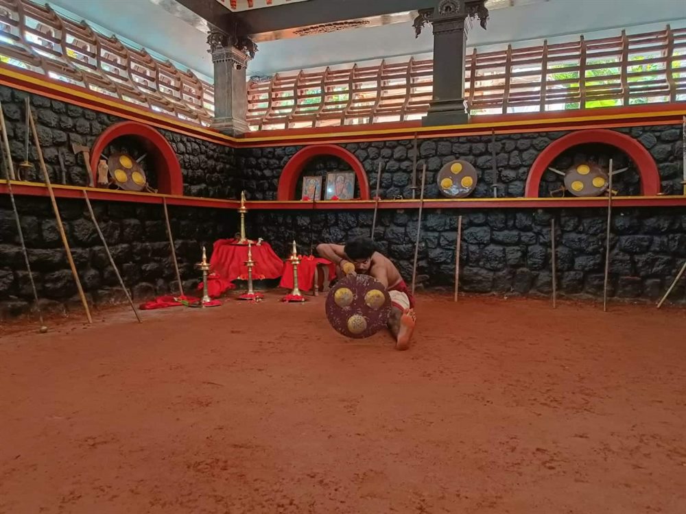 Rolling practice with a shield across the floor of the Kalari