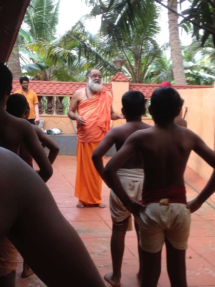 Guruji instructing a group of students in the open courtyard of the Kalari