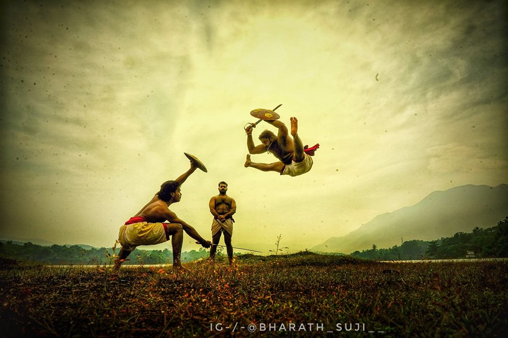 A practitioner turning in mid-air above his partner against the evening sky