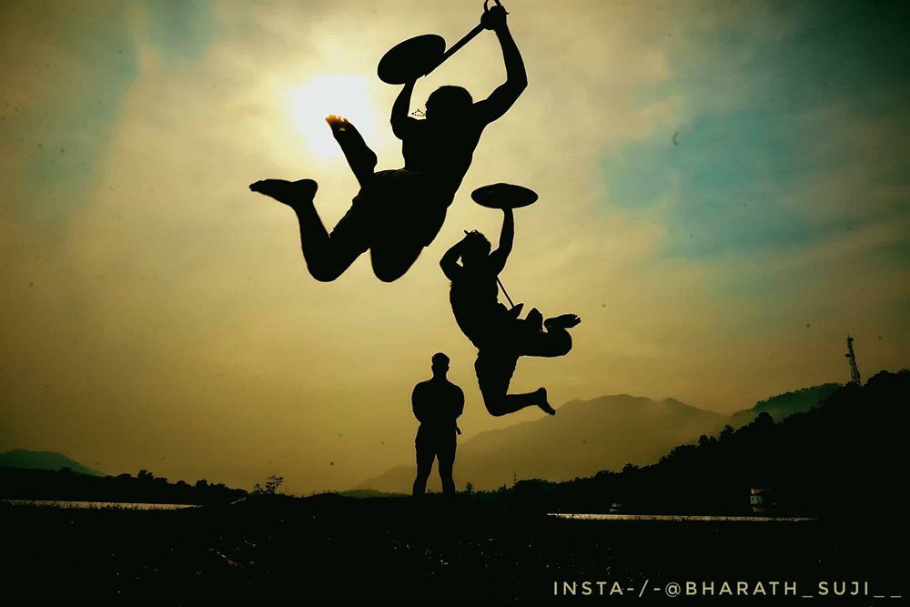 Two leaping figures silhouetted against the sky, weapons raised