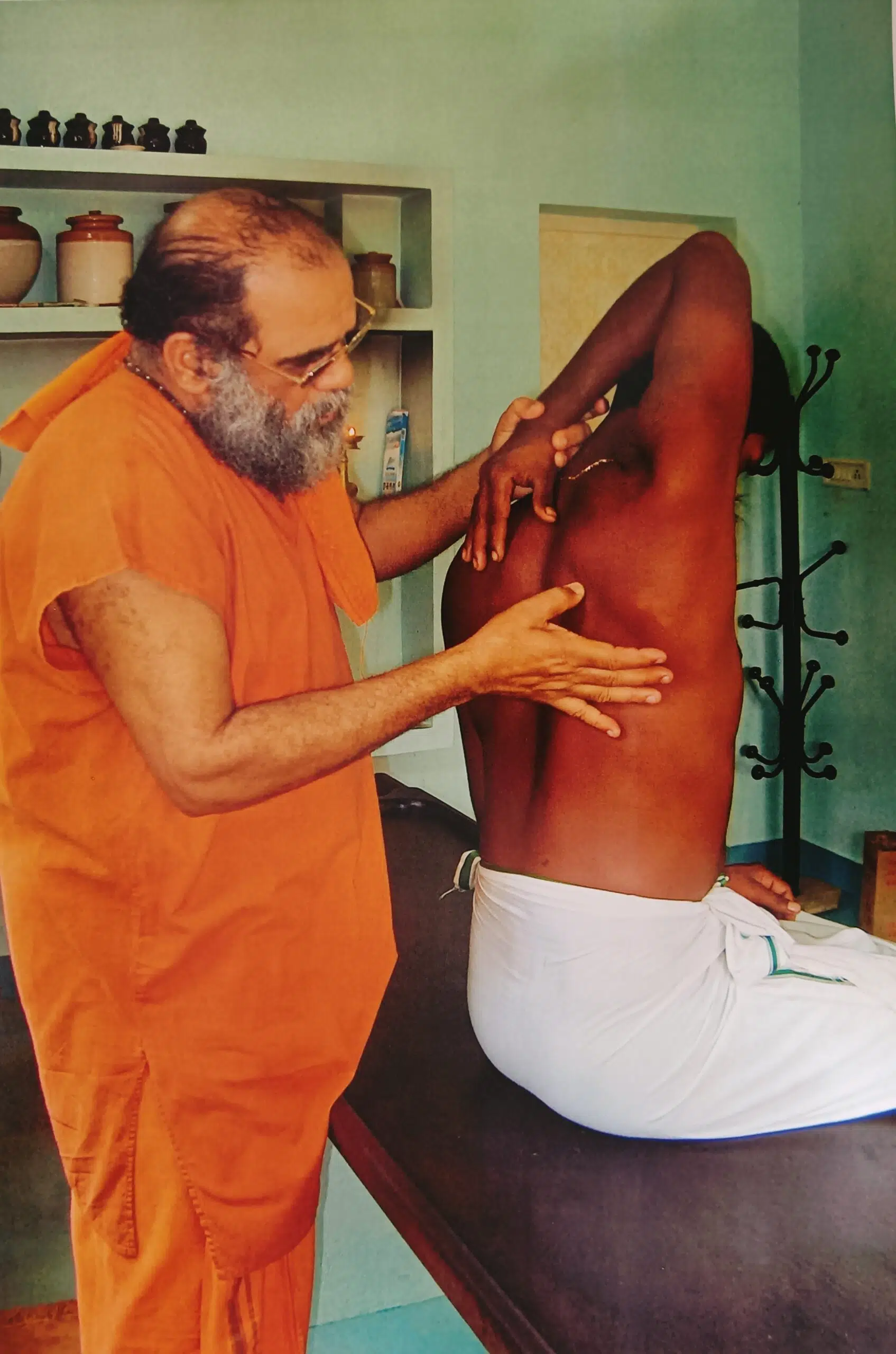 Therapist performing a traditional Uzhichil oil massage at the ashram